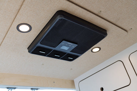 Dometic AC unit and recessed lights in an RV rental, providing comfort on the fabric-lined ceiling.