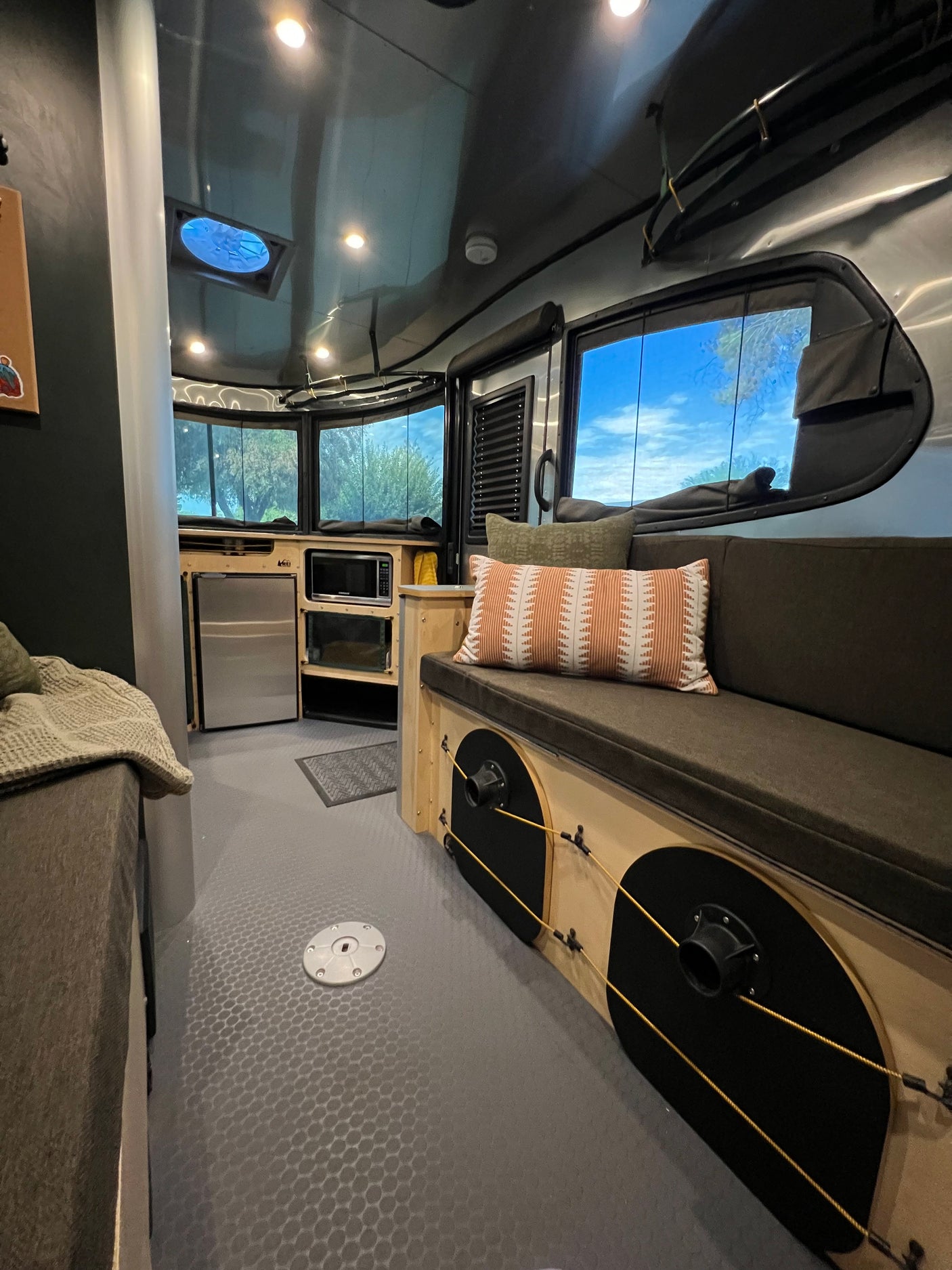 Inside a modern **rv rental**: comfy seating, compact kitchen, and large windows offering nature views. Perfect for your next travel adventure.