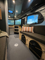 Inside a modern **rv rental**: comfy seating, compact kitchen, and large windows offering nature views. Perfect for your next travel adventure.