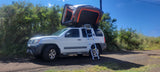 A white SUV with an open rooftop tent and ladder, ideal for an RV rental outdoor adventure.
