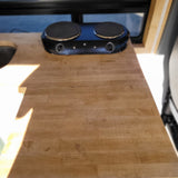 RV rental's compact kitchen features a two-burner electric cooktop on a warm, wooden countertop for easy meals on the go.
