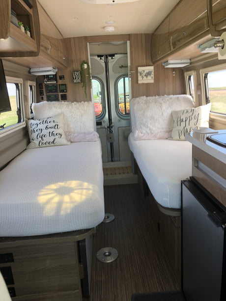 RV rental interior: twin beds, light wood decor, and kitchen essentials create a comfy, mobile home for travel.