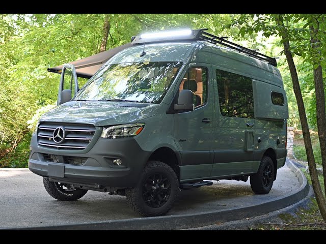  a man with a fishing rod standing beside it on a dirt path with trees.|Sage green Mercedes-Benz camper van — photo 2