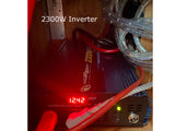 A 2300W Power Bright inverter in an RV rental displays 12.42V, providing AC power for off-grid electrical needs.