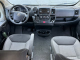 Front cabin view of an RV rental, featuring driver's controls, dashboard, and two comfortable seats.