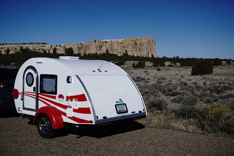White teardrop camper (an excellent rv rental option) parked in an Arizona desert landscape with striking cliffs. — photo 2