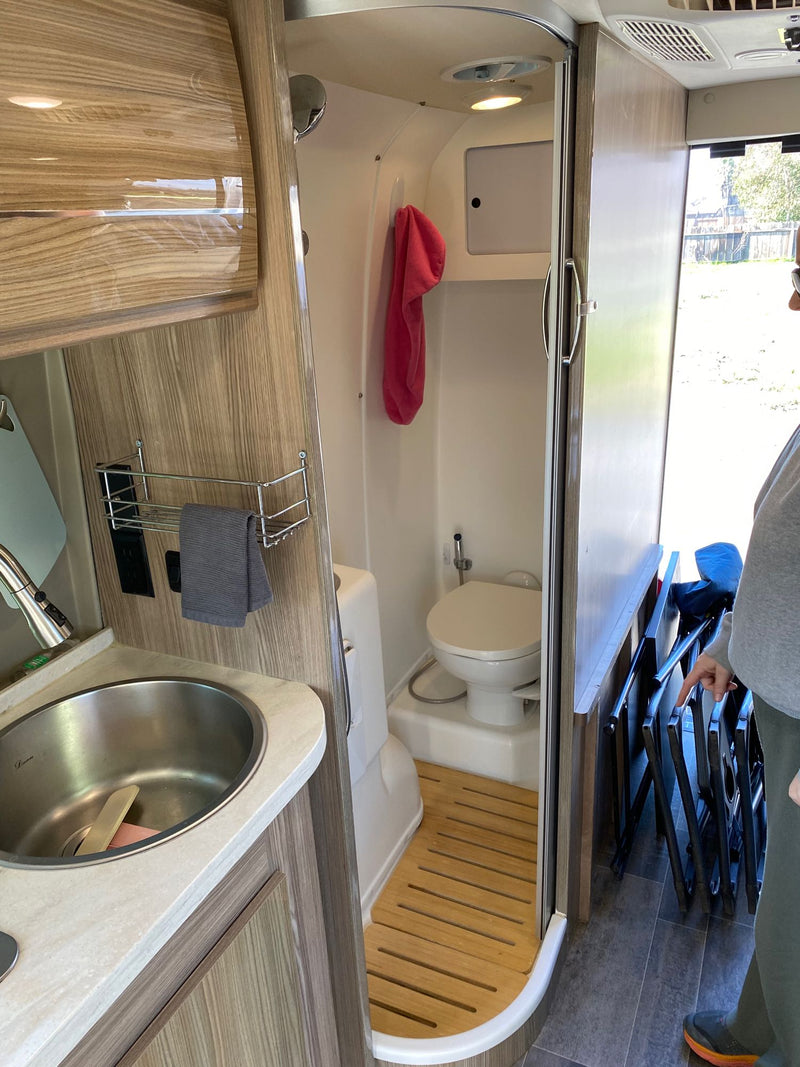  side door open to reveal bed & compact interior.|Interior view of a compact rv rental — photo 9