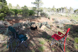 RV rental adventure? Relax at your campsite! Two chairs & fire pit await in nature's quiet embrace.
