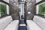 Step inside this luxurious rv rental: a spacious interior with light leather seating, sleek wood panels, and modern amenities.