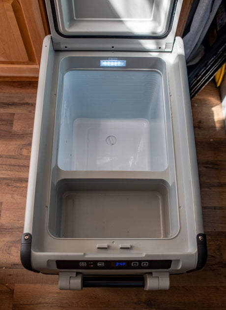 Open portable RV rental fridge interior with 34F display. Perfect for keeping food/drinks cold on road trips.