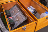 RV rental storage: Open wooden drawers reveal camping stove, propane, water, and kitchen essentials.