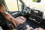 Explore in comfort! This rv rental's sleek van interior features brown leather seats, modern dashboard, & infotainment screen.