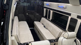 A plush **rv rental** interior showcases quilted cream benches, dark wood accents, and ambient lighting, offering luxurious travel comfort.