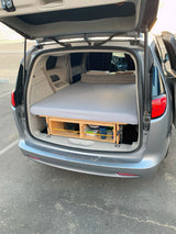 This DIY minivan camper conversion features a comfy bed platform over storage, perfect for an rv rental alternative!