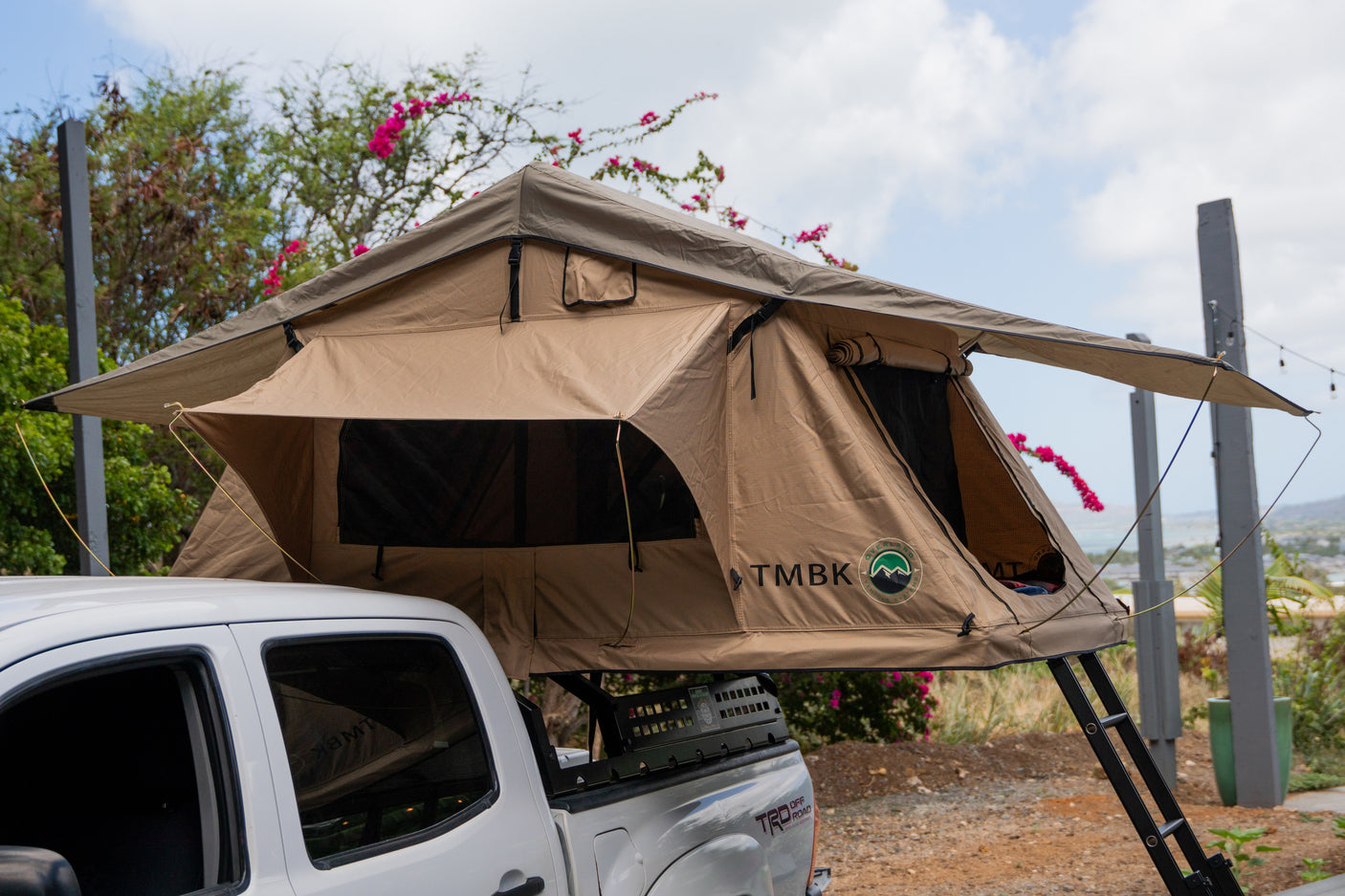Tan rooftop tent on a white pickup truck.