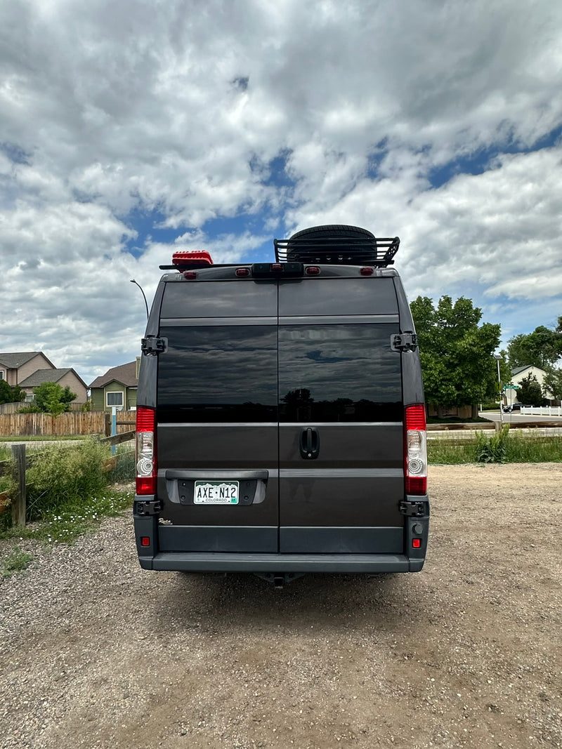 Rear view of an RV rental camper van parked on gravel, featuring a roof rack, spare tire, and Colorado license plate. — photo 20