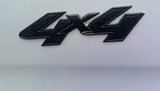A black '4x4' emblem, slightly dirty, on a gray vehicle body. Indicates off-road capability for your rv rental.