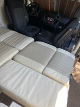 RV rental interior: versatile, light-toned cushions forming a bed/seat, with the front cabin visible beyond.
