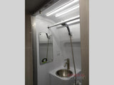 Compact RV wet bath for rv rental, showing a shower head, sink, and mirror. Ideal for small spaces.