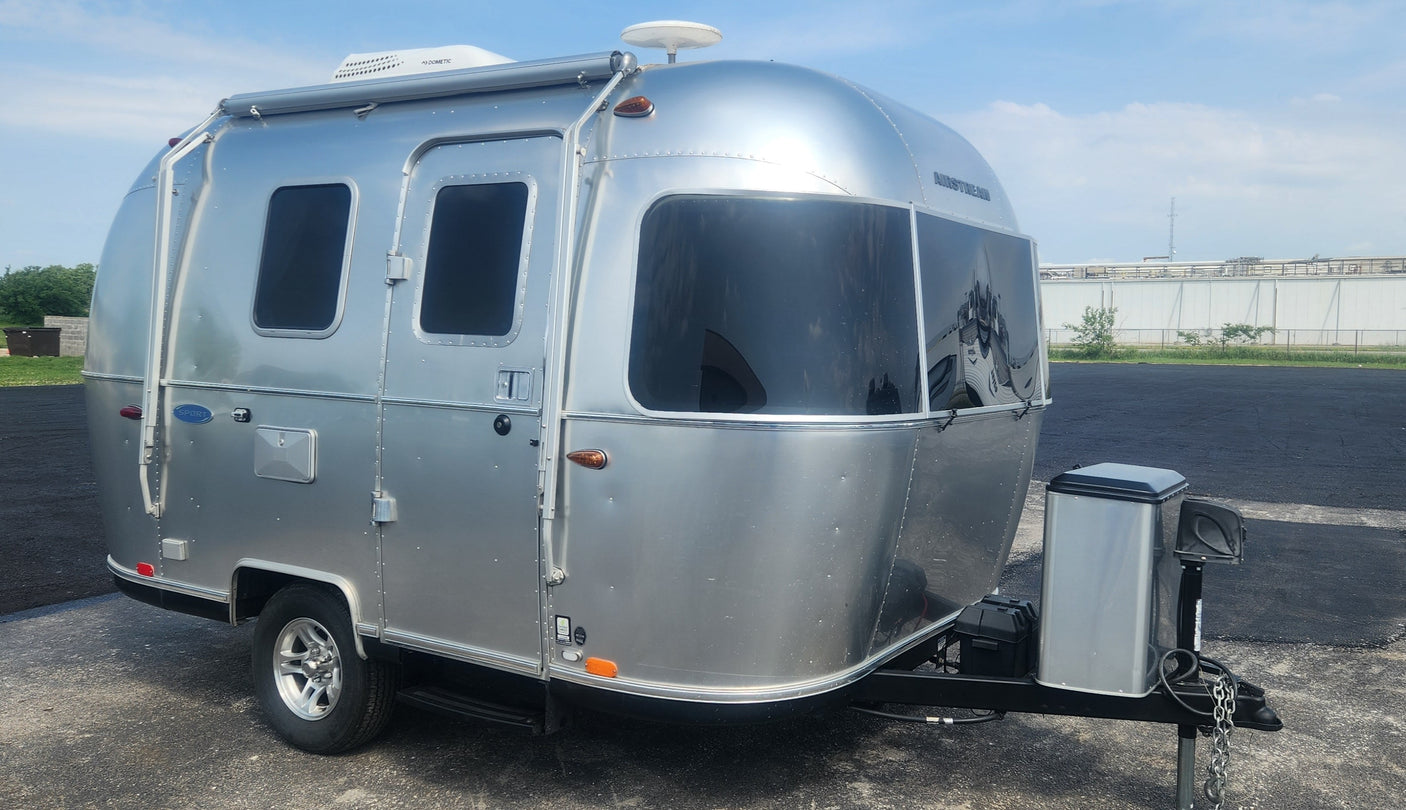 A sleek silver Airstream travel trailer parked outdoors, ready for your next RV rental trip.