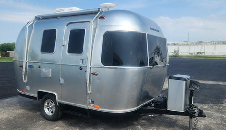 A sleek silver Airstream travel trailer parked outdoors, ready for your next RV rental trip.