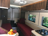 RV rental interior: cozy beds, efficient kitchen, ambient lighting. Explore the open road in comfort.