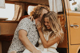 Happy couple enjoying their RV rental adventure inside a cozy camper van, laughing and embracing.