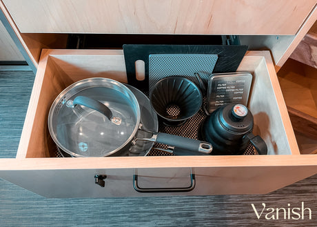 Compact kitchen essentials in an RV rental drawer: pot, pour-over coffee maker, kettle, and cutting boards.