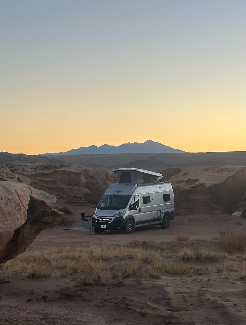  and a rear bed with mountain views.|RV rental interior showing a ladder to a pop-top bed — photo 4