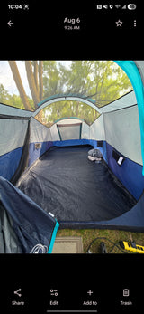 Spacious tent interior set up at an RV rental site, showing ample room, mesh windows, and power access for camping.