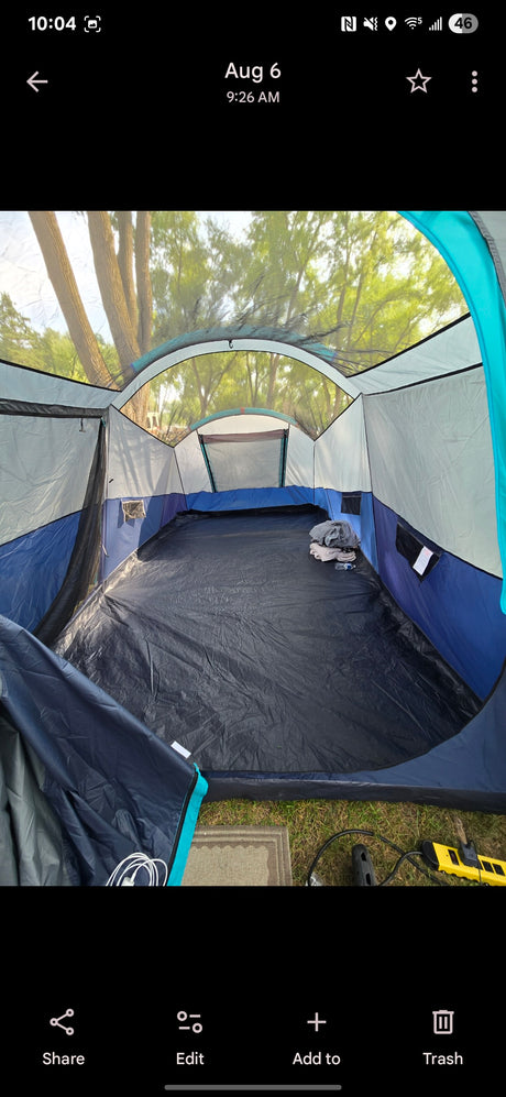 Spacious tent interior set up at an RV rental site, showing ample room, mesh windows, and power access for camping.