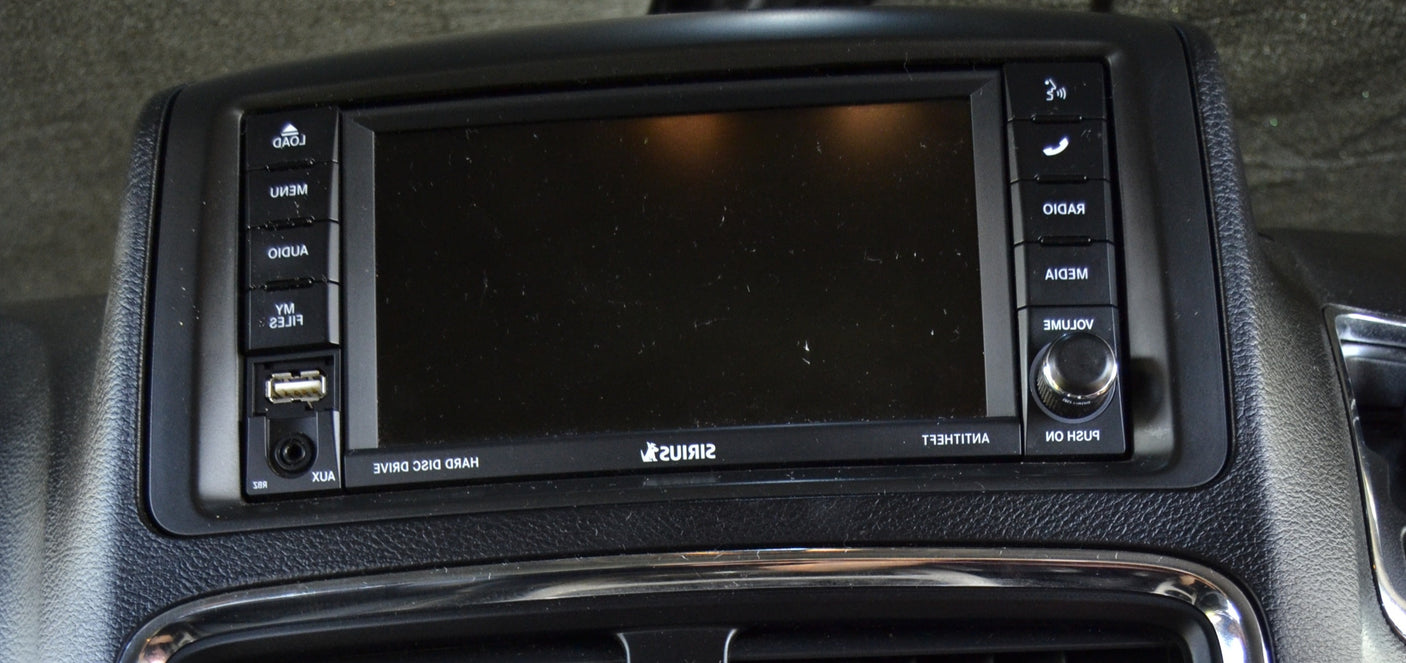 An RV rental's black car stereo/infotainment system with a blank screen, USB, AUX, and control buttons for media, radio, and volume.