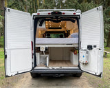Inside this cozy rv rental camper van: a comfortable bed, smart storage, and a portable water heater for your next adventure.