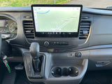 Interior of an RV rental showing the dashboard with a large infotainment screen displaying a map, climate controls, and gear shifter.