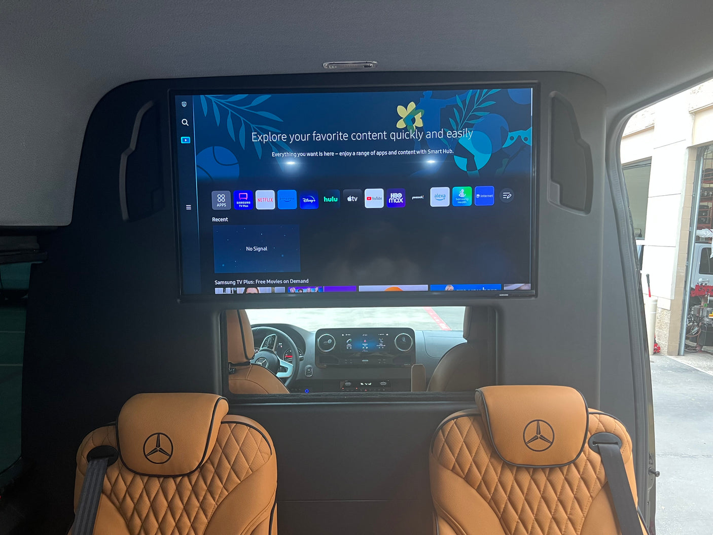 Luxury RV rental interior with Mercedes-Benz seats & a large smart TV showing streaming apps for onboard entertainment.