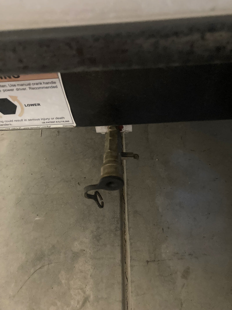 An RV rental's manual crank port for lowering stabilizer jacks, including a warning label. — photo 20