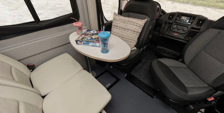 Cozy RV rental interior showing a small table with "Clue" game and tumblers, surrounded by comfortable seating.