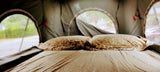 Cozy bed and pillows inside an RV rental tent, perfect for comfortable glamping adventures.