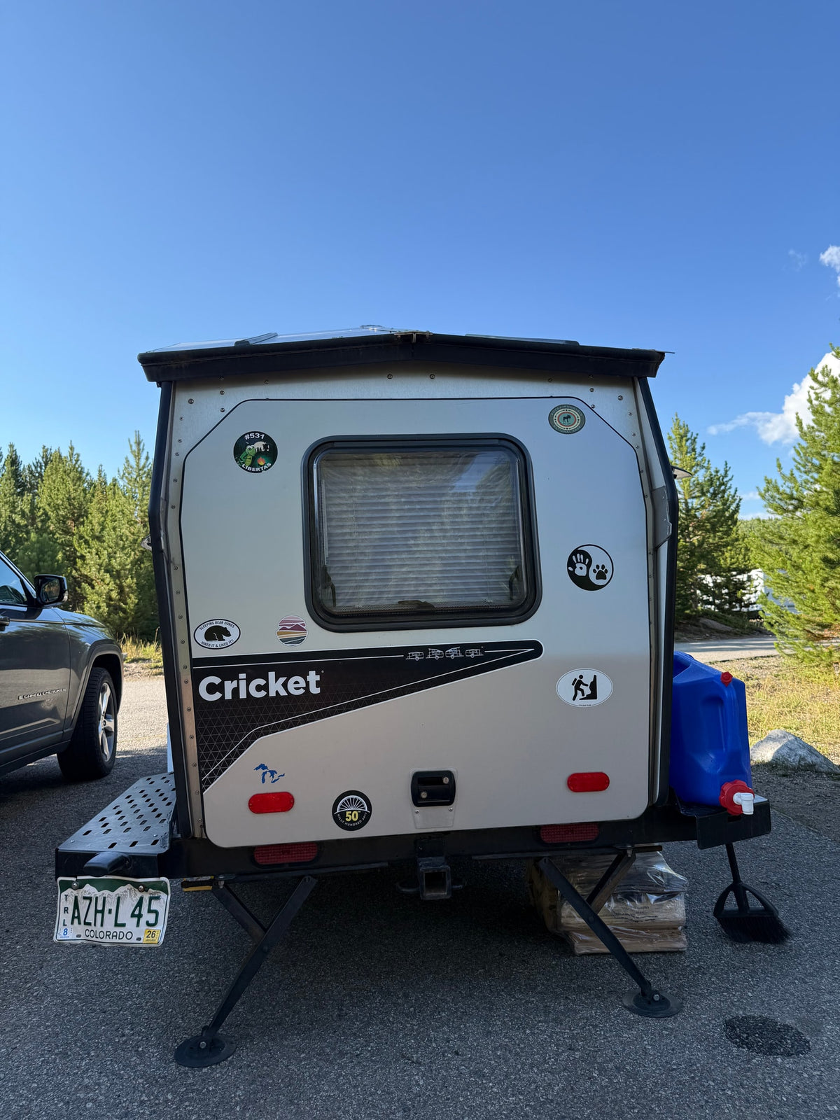 A small, light-colored Cricket travel trailer, possibly an RV rental, parked outdoors, displaying a Colorado license plate. — photo 6
