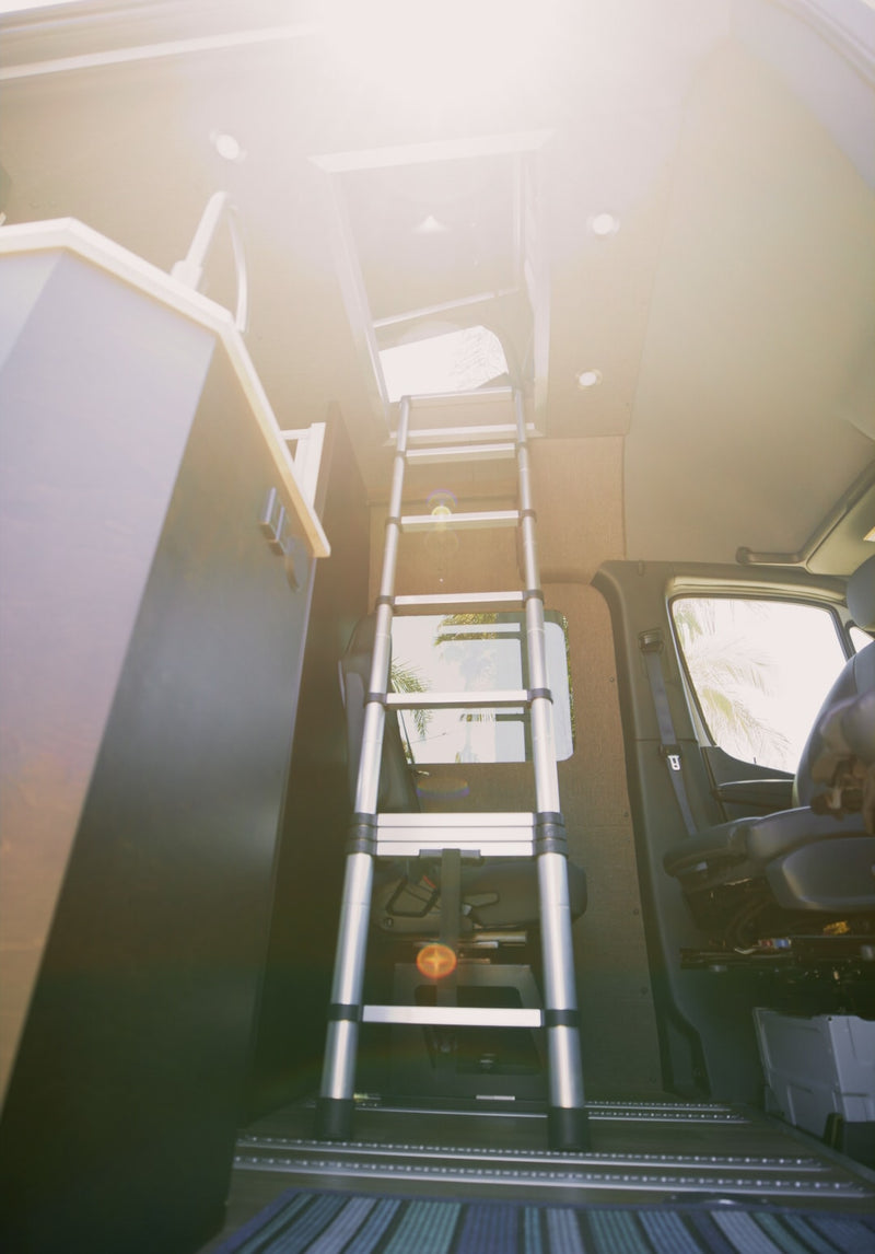 RV rental interior: A ladder leads to a bright rooftop hatch. Sunlit camper van, perfect for van life. — photo 7