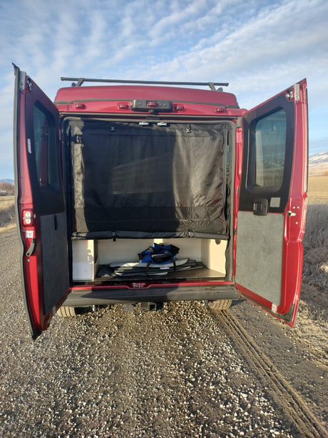 This RV rental camper van showcases its organized rear storage and privacy screen. Ideal for outdoor adventures and mobile living.