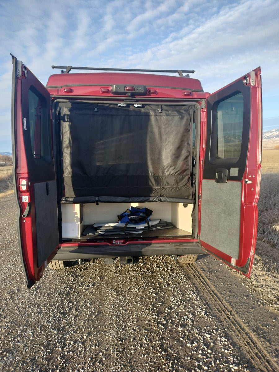 This RV rental camper van showcases its organized rear storage and privacy screen. Ideal for outdoor adventures and mobile living.