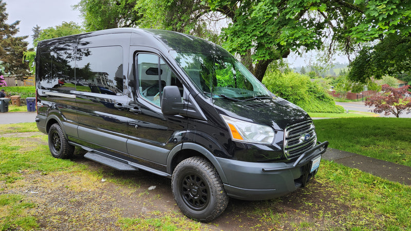 Black customized Ford Transit van for rv rental, parked on grass. Ideal for adventure. — photo 1