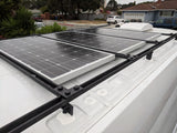 Three large solar panels on a white rv rental van's roof, mounted on a sturdy black rack. Ideal for off-grid power.