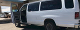 A white passenger van, with its driver's door open, appears ready for service. Perfect for group travel or your next RV rental adventure.
