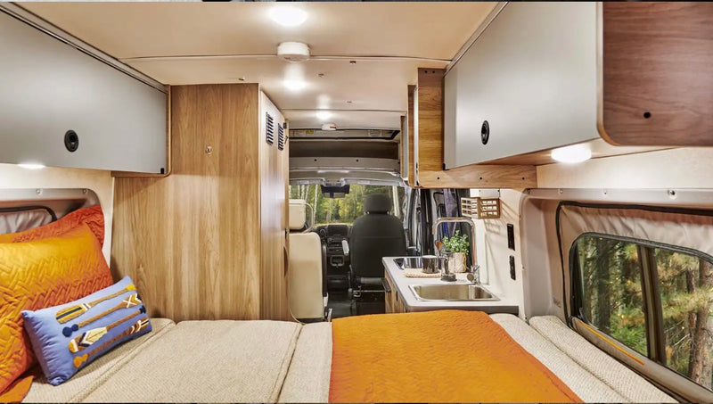  is parked in a stunning national park for your adventure.|This rv rental shows a cozy interior with a kitchen — photo 2