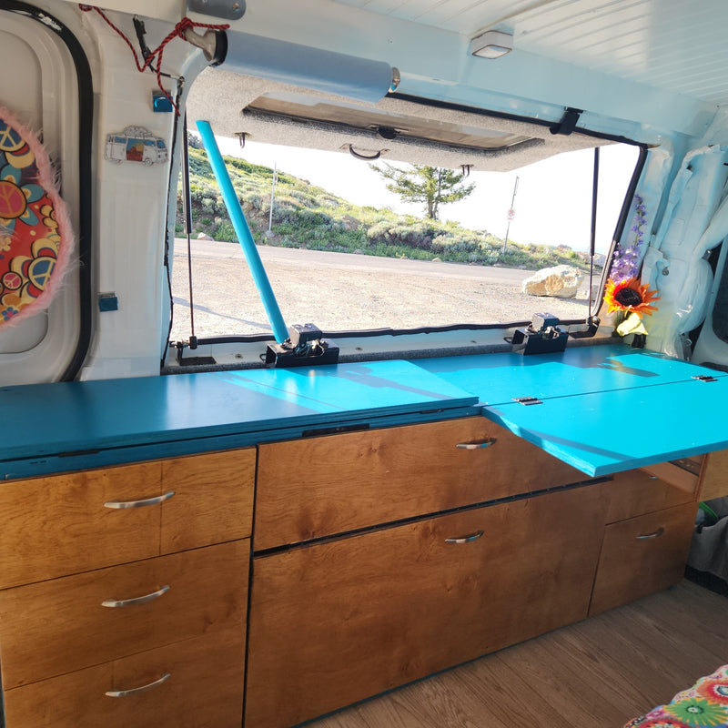 Custom camper van interior with vibrant blue counter & wooden storage, perfect for an RV rental adventure with stunning views. — photo 20