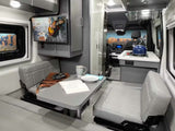 Inside a modern RV rental: a gray camper van interior with a dinette, kitchen area, and TV. Ready for your next adventure!