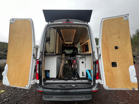 Rear view of a customized RV rental camper van, showing two mountain bikes & built-in storage. Ideal for adventures.
