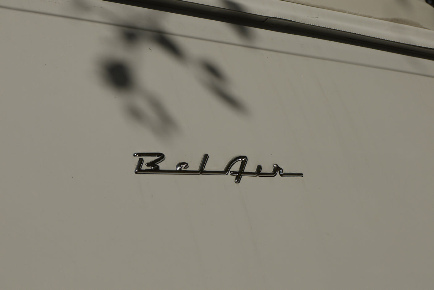 Chrome 'Bel Air' emblem on a light-colored RV rental, showcasing its classic lettering and surface reflections.